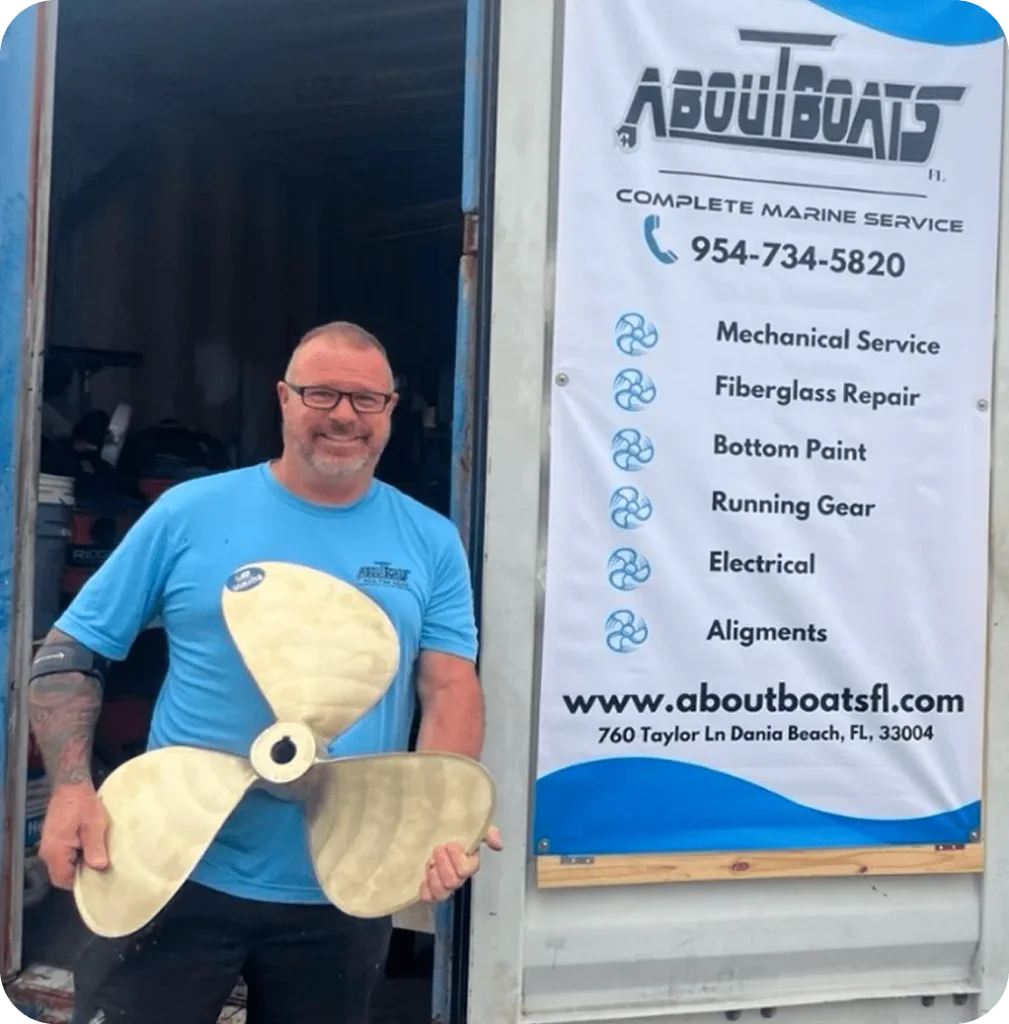 About Boats FL technician holding yacht propeller at Playboy Marina in Dania Beach